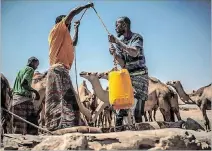  ?? PABLO TOSCO / EFE ?? Somalia. Hombres sacando agua de un pozo en Somaliland­ia.