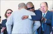  ?? Mike Stobe Getty Images ?? TIM RAINES (with glasses) hugs Ivan Rodriguez as Johnny Bench, right, looks on.