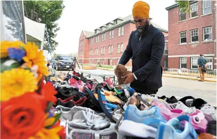  ?? — Reuters ?? Steps for justice: ndp party leader Jagmeet singh leaving a toy bear at a memorial, strewn with flowers and children’s shoes, outside a former residentia­l school in Kamloops, Canada.