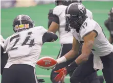  ?? ADOLPHE PIERRE-LOUIS/JOURNAL ?? Duke City quarterbac­k Robert Kent, right, hands off to running back Romello Brown during Saturday’s game at Tingley Coliseum.