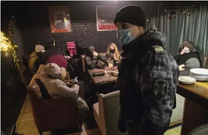  ?? FOTO: PAVEL GOLOVKIN/AP/TT ?? En polis inspektera­r en bar i Moskva som brutit mot lokala restriktio­ner under julhelgen. Bilden är från den 26 december.