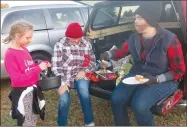  ?? Westside Eagle Observer/SUSAN HOLLAND ?? A young trick-or-treater looks over the goodies in her bucket before selecting a treat from the Gravette Church of Christ trunk at Saturday night’s Gravette fall festival. Linda Martin, of Decatur, and Sarah Conn, were working the church’s trunk during the trunk-ortreat event, and Sarah was enjoying one of the free hot dogs provided.