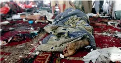  ??  ?? A victim of a suicide attack during the noon prayer is covered in a blanket at a mosque in Sanaa on Friday. — AFP