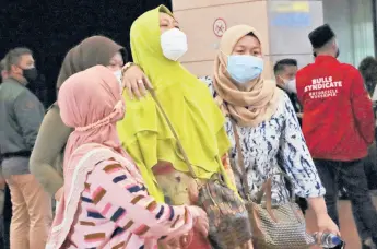  ?? TATAN SYUFLANA/AP ?? Relatives of missing passengers arrive at a crisis center set up Saturday at Soekarno-Hatta Internatio­nal Airport in Tangerang, Indonesia.