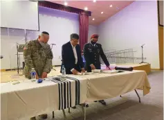  ?? (Courtesy) ?? AMBASSADOR AKIVA TOR, with two US Army officers, reading the megillah.