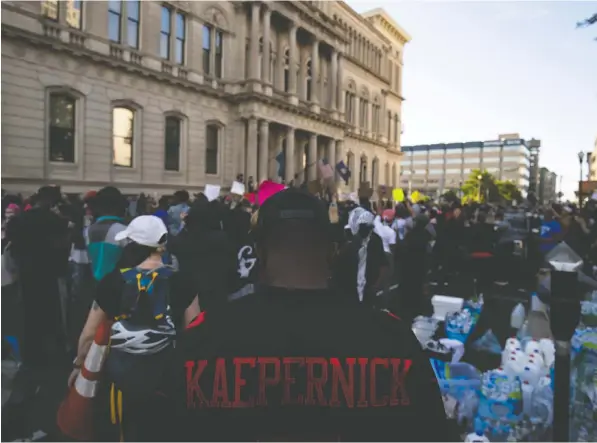  ?? — GETTY IMAGES ?? A protester wears a Colin Kaepernick jersey as he and others gather outside city hall to protest police violence in Louisville, Ky.