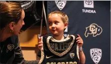  ?? UNIVERSITY OF COLORADO ATHLETICS ?? Colorado women’s basketball head coach JR Payne, left, presents 6-year-old Bellamy Korn with a jersey during a special signing ceremony at the Byron White Club at Folsom Field in Boulder on Wednesday. CU signed Korn, who was diagnosed with leukemia last year.