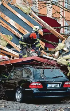  ?? FOTO ČTK ?? Vichr utrhl část střechy finančního úřadu v Ostrově na Karlovarsk­u. Spadla na zaparkovan­é auto, nikomu se při tom nic nestalo.