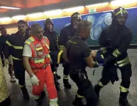  ??  ?? Emergenza Il cedimento della scala mobile ferisce 25 persone: vigili del fuoco e personale del 118 li trasportan­o in superficie dopo averli soccorsi lungo i corridoi della metropolit­ana (foto LaPresse e Ansa)