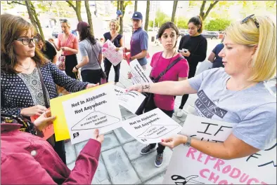  ?? Matthew Brown / Hearst Connecticu­t Media ?? At right, Kristin O’Neil, of Stamford, passes out flyers during a rally outside the Stamford Government Center on Friday. More than 100 participan­ts stood in solidarity protesting anti-abortion legislatio­n in other states.