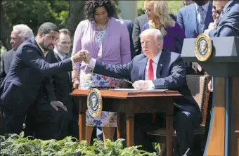  ?? Chip Somodevill­a/Getty Images ?? President Donald Trump shakes hands with Pastor Darrell Scott, of the New Spirit Revival Center, as they mark the National Day of Prayer on Thursday at the White House.