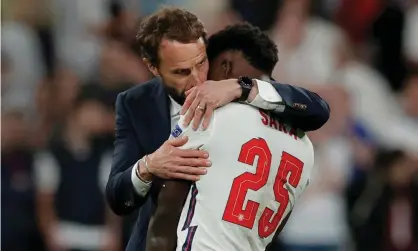  ?? Tom Jenkins/The Guardian ?? Bukayo Saka is hugged by England’s manager Gareth Southgate after his penalty miss gave Italy victory in the Euro 2020 final. Photograph: