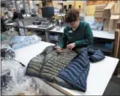  ?? ROBERT F. BUKATY — THE ASSOCIATED PRESS ?? A worker marks a coat that was returned to the LL Bean retail store in Freeport, Maine.