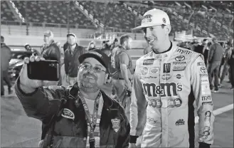  ?? JOHN RAOUX/AP PHOTO ?? Kyle Busch, right, poses for a selfie photo with a race fan before the first of two qualifying races on Thursday at Daytona Internatio­nal Speedway.