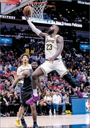  ?? ?? LeBron culmina una penetració­n ante la mirada de Zion en el Pelicans-Lakers del domingo.