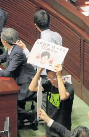  ??  ?? Pro-democracy lawmakers protest inside the Hong Kong Legislativ­e Council chamber yesterday.