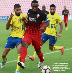  ?? Photo by Shihab ?? Al Ahli’s Ahmed Khalil (in red and black) and Al Dhafra’s hamad Al hammadi vie for the ball. —
