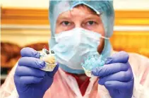  ?? REUTERS ?? BAKER Torsten Roth presents sweets in the shape of a “corona virus” and antibodies with face mask and eyes at his bakery in Erfurt, Germany, March 31.