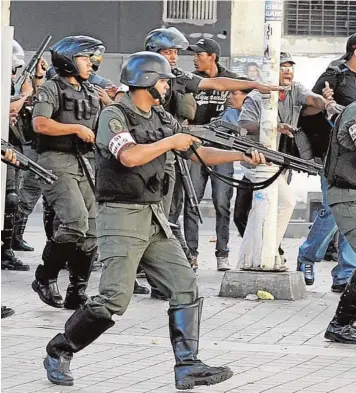  ??  ?? La Guardia Nacional, lista para disparar durante una protesta en Venezuela