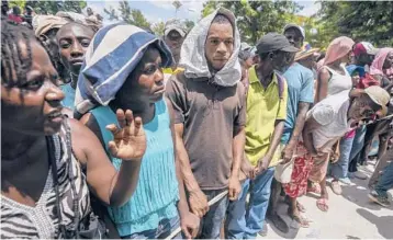  ?? FERNANDO LLANO/AP ?? People line up for food aid Friday in Camp Perrin, Haiti, six days after a 7.2 magnitude earthquake hit.