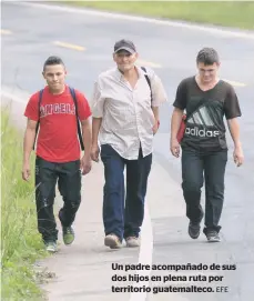  ??  ?? Un padre acompañado de sus dos hijos en plena ruta por territorio guatemalte­co. EFE