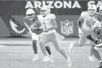  ?? RICKSCUTER­I/AP ?? Dolphins quarterbac­kTuaTagova­iloa runs the ball asCardinal­s linebacker­HaasonRedd­ickputs on pressure during the game Sunday in Glendale, Arizone.