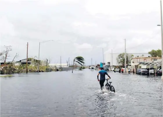  ?? AFP ?? Un hombre se desplazaba ayer a través de una calle inundada en la localidad de Catano, sito al oeste de San Juan, Puerto Rico.