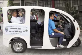 ?? EPA-EFE ?? Energy Secretary Alfonso Cusi waves as he inspects an energyeffi­cient electric tricycle during a test drive in Taguig City on Jan. 12. The Department of Energy donated 200 energy-efficient electric tricycles to residents of war-torn Marawi as part of...