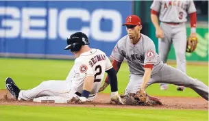  ?? GEORGE BRIDGES/ASSOCIATED PRESS ?? Houston’s Alex Bregman, left, slides into second base with a double ahead of the tag of the Los Angeles Angels’ Andrelton Simmons on Thursday. The Astros took a 2-1 victory.
