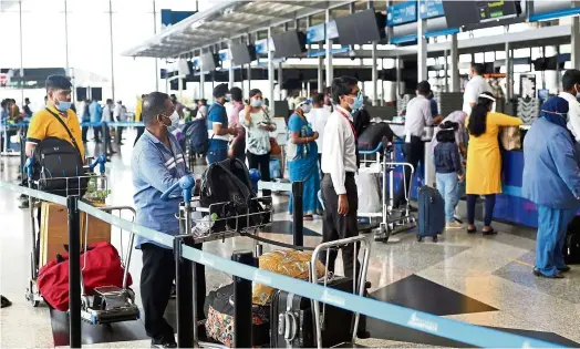  ?? — IZZRAFIQ ALIAS/The Star ?? Plans underway
Travellers waiting to check in at airline counters at the KLIa departure hall. While many airline counters remain quiet, some are bustling.