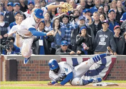  ?? Wally Skalij Los Angeles Times ?? CUBS third baseman Kris Bryant is upended as Dodgers base runner Andrew Toles slides safely to load the bases in the eighth inning in Game 1 of the National League Championsh­ip Series. The Cubs defeated the Dodgers, 8-4.