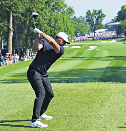  ??  ?? High and mighty: Brooks Koepka drives off at the 18th yesterday on his way to a record-equalling 63