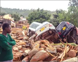  ??  ?? In this picture combo, a survivor watches in disbelief the trail of destructio­n and death wrought by Cyclone Idai in Chimaniman­i and (right picture) an aerial view of Ngangu Mountain and the suburb named after it