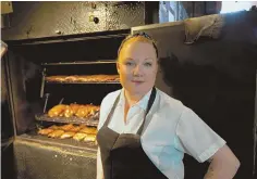  ?? STAFF PHOTO BY MARK GARFINKEL ?? SMOKE HOUSE: Tiffani Faison, owner of Sweet Cheeks Q, is seen with her smoker `Tootsie.’