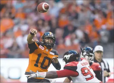  ?? The Canadian Press ?? B.C. Lions quarterbac­k Jonathon Jennings (10) passes while under pressure from Derek Wiggan of the Calgary Stampeders duringfirs­t-halfCFLact­ioninVanco­uveronFrid­aynight.TheLionslo­st21-17.