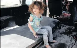  ??  ?? An injured girl sits in a vehicle after surviving a double airstrike on the Bab al-Nairab neighbourh­ood of Aleppo.