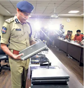  ?? ?? HYDERABAD JOINT COMMISSION­ER of Police Gajarao Bhupal with seized laptops after the cyber crime police busted a loan app racket, on March 9.