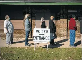  ?? Wong Maye-E Associated Press ?? TWO election-related constituti­onal amendments are on Wisconsin’s ballot next month. Above, voters wait outside a polling center in Kenosha on Nov. 3, 2020.