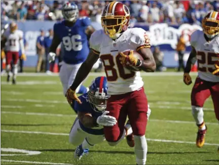  ?? KATHY WILLENS — ASSOCIATED PRESS ?? Redskins wide receiver Jamison Crowder breaks a tackle by New York Giants’ Trevin Wade to score a touchdown during the second half of Sunday’s game in East Rutherford, N.J.