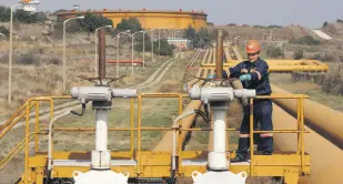  ??  ?? A worker checks the valve gears of pipes linked to oil tanks at Turkey’s Mediterran­ean port of Ceyhan, southern Turkey, Feb. 19, 2014.