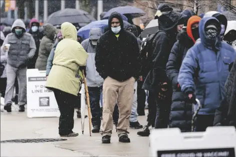  ?? ASSOCIATED PRESS ?? IN THIS FEB. 19 PHOTO, people wait in line at a 24-hour, walk-up COVID-19 vaccinatio­n clinic hosted by the Black Doctors COVID-19 Consortium at Temple University’s Liacouras Center in Philadelph­ia.