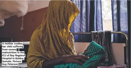  ?? ?? A mother cradles her child suffering from severe malnutriti­on in the ICU of Bay Regional Hospital in Baidoa, Somalia. Picture: Guy Peterson