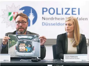  ?? FOTO: DAVID YOUNG/DPA´ ?? Polizeispr­echer André Hartwich und Staatsanwä­ltin Laura Hollmann zeigen ein Bild des Opel, mit dem der Kunde des Dealers das Rauschgift abholen wollte. Es war in einer Kiste Altpapier versteckt.