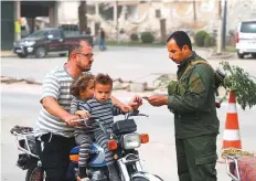  ?? AFP ?? A security man checks a man’s identifica­tion documents at a checkpoint securing vehicles entering Raqqa.