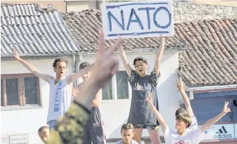  ?? ?? Prizren residents brandish a placard with Nato written on it to celebrate the withdrawal of Serbian forces from their city, in Prizren.