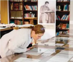  ??  ?? A woman checks one of Albert Einstein’s manuscript­s on display in the Givat Ram Hebrew University of Jerusalem on Wednesday. — AFP