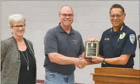  ?? Mona Weatherly ?? Captain Dan Hanson of the Broken Bow Police Department receives a plaque of appreciati­on from Police Chief Steve Scott. Hanson is retiring from the BBPD. From left are Hanson’s wife, Barb; Hanson; and Chief Scott.