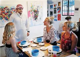  ??  ?? Mohamed Al Rais describes his traditiona­l dress during a Refuge Supper Club gathering at Elemental Coffee in downtown Oklahoma City.