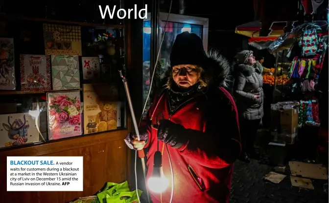  ?? AFP ?? BLACKOUT SALE.
A vendor waits for customers during a blackout at a market in the Western Ukrainian city of Lviv on December 15 amid the Russian invasion of Ukraine.