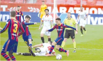  ?? — AFP photo ?? Barcelona’s Spanish midfielder Pedri (left) and Barcelona’s US defender Sergino Dest challenge Sevilla’s Dutch midfielder Karim Rekik (centre) during the Spanish league football match between Sevilla FC and FC Barcelona at the Ramon Sanchez Pizjuan stadium in Seville.